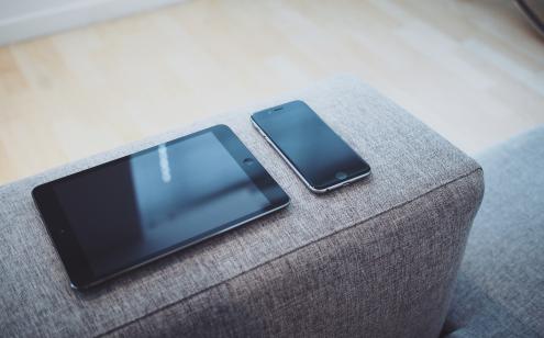 Tablet and phone on sofa arm